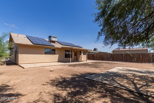 back of house with a patio, central air condition unit, and solar panels