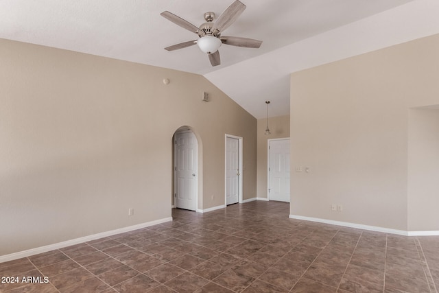 tiled spare room with ceiling fan and vaulted ceiling