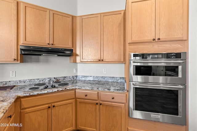 kitchen featuring light stone countertops, appliances with stainless steel finishes, and light brown cabinetry