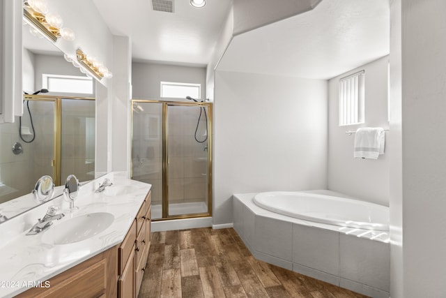 bathroom featuring wood-type flooring, vanity, a wealth of natural light, and independent shower and bath