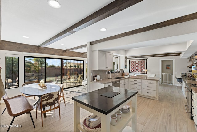 kitchen featuring white cabinetry, sink, beamed ceiling, and radiator heating unit