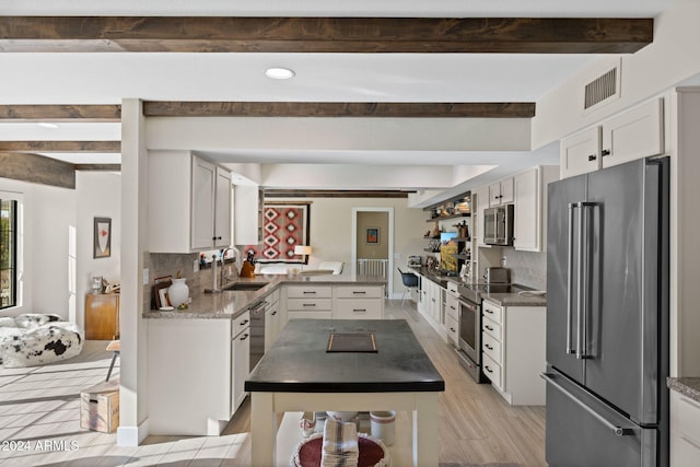 kitchen featuring white cabinets, backsplash, stainless steel appliances, and sink