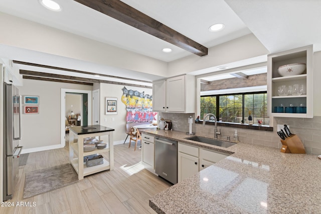 kitchen with beam ceiling, white cabinetry, sink, and appliances with stainless steel finishes