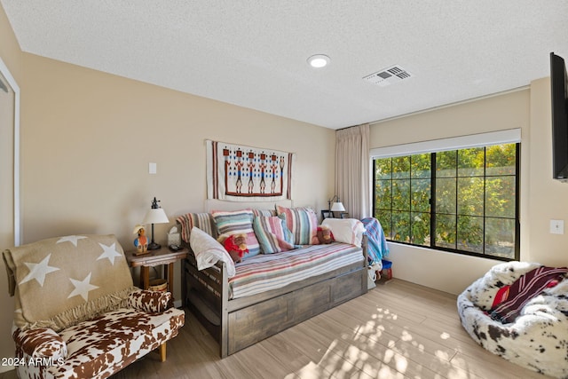 bedroom featuring a textured ceiling and hardwood / wood-style flooring