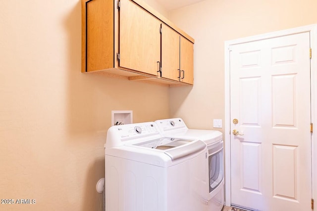 washroom featuring cabinets and independent washer and dryer