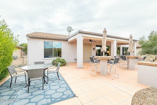 view of patio / terrace featuring ceiling fan and an outdoor kitchen