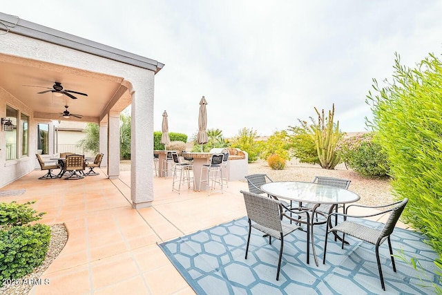 view of patio / terrace with ceiling fan, exterior bar, and exterior kitchen