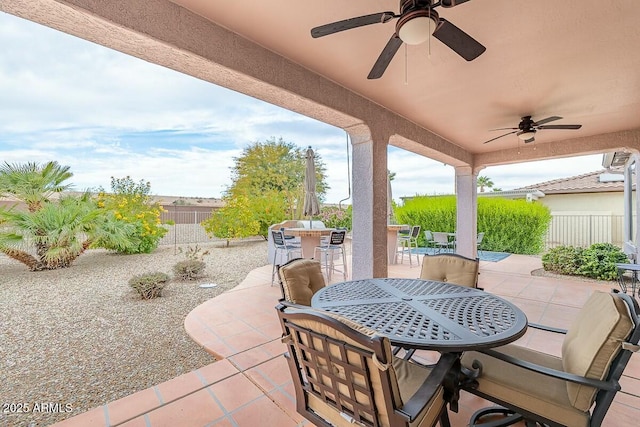 view of patio featuring ceiling fan and a bar