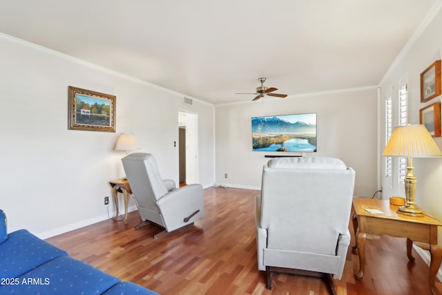 living room featuring wood-type flooring, ceiling fan, and ornamental molding