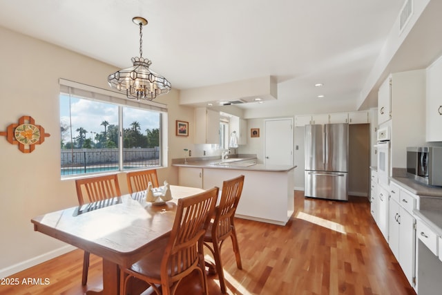 dining space featuring a chandelier, hardwood / wood-style flooring, and sink