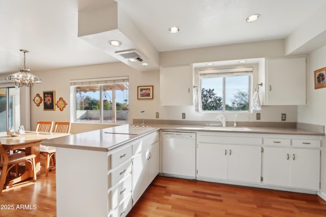 kitchen with pendant lighting, dishwasher, white cabinets, and sink