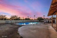 pool at dusk featuring a patio