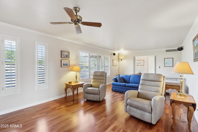 living room with ceiling fan, hardwood / wood-style floors, plenty of natural light, and ornamental molding