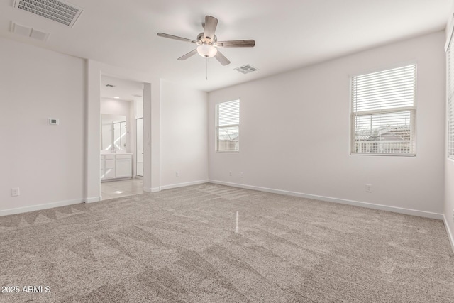 carpeted spare room featuring ceiling fan