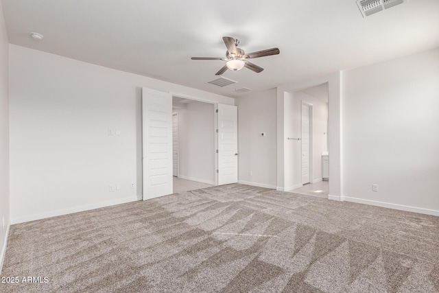 unfurnished bedroom featuring ensuite bathroom, ceiling fan, and light colored carpet