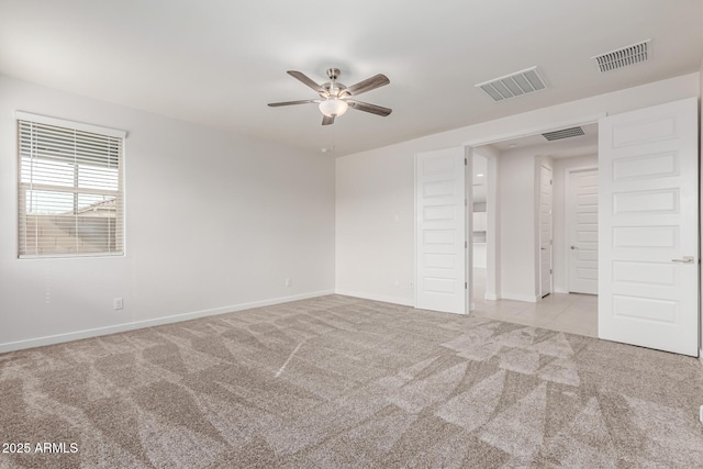 carpeted spare room featuring ceiling fan