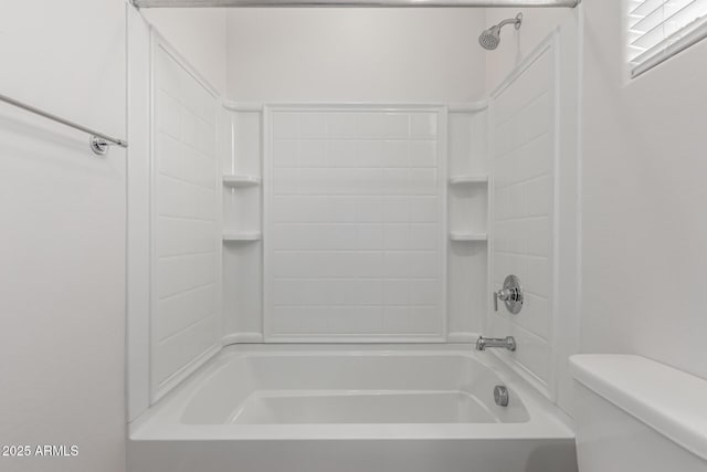 bathroom featuring tub / shower combination and toilet