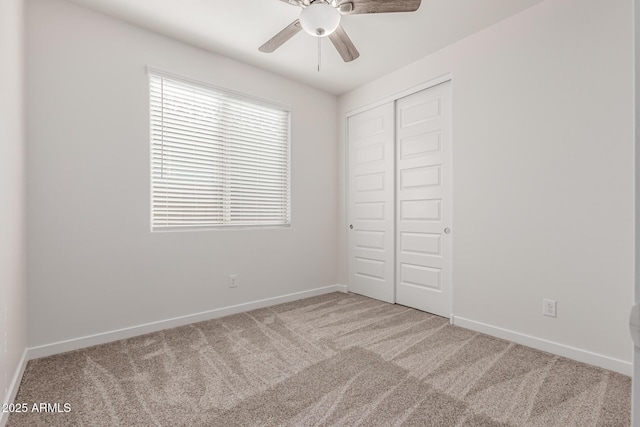 unfurnished bedroom featuring light carpet, a closet, and ceiling fan