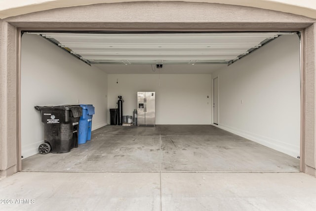 garage with stainless steel refrigerator with ice dispenser