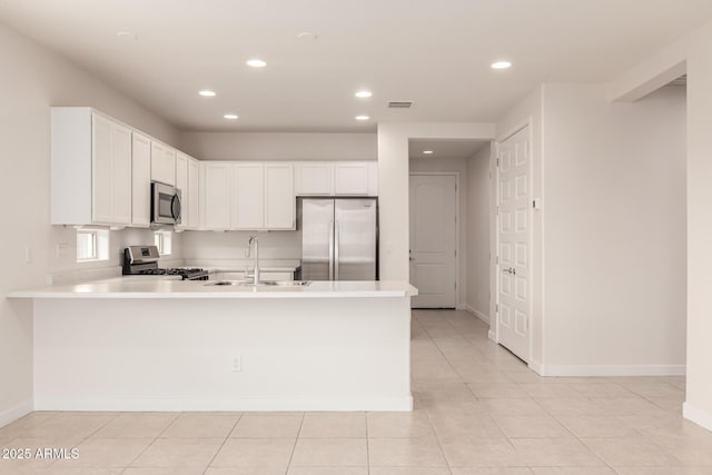 kitchen featuring white cabinetry, kitchen peninsula, sink, light tile patterned floors, and appliances with stainless steel finishes