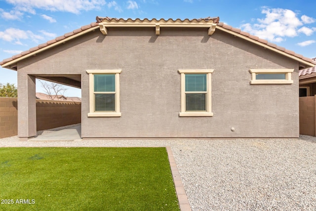 back of property with a lawn and a patio area