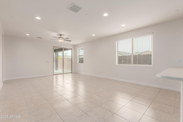 spare room with ceiling fan and light tile patterned floors