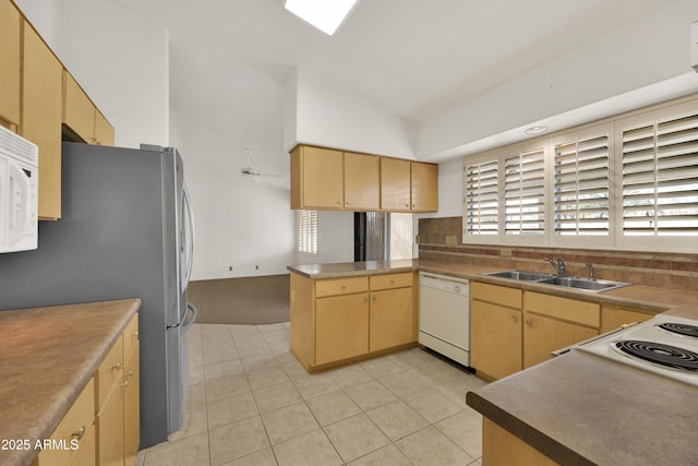 kitchen featuring light brown cabinetry, sink, vaulted ceiling, kitchen peninsula, and white appliances