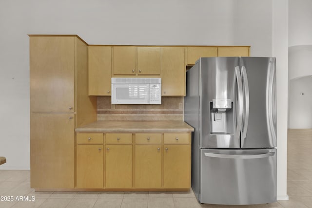 kitchen featuring light tile patterned flooring, light brown cabinets, decorative backsplash, and stainless steel fridge with ice dispenser