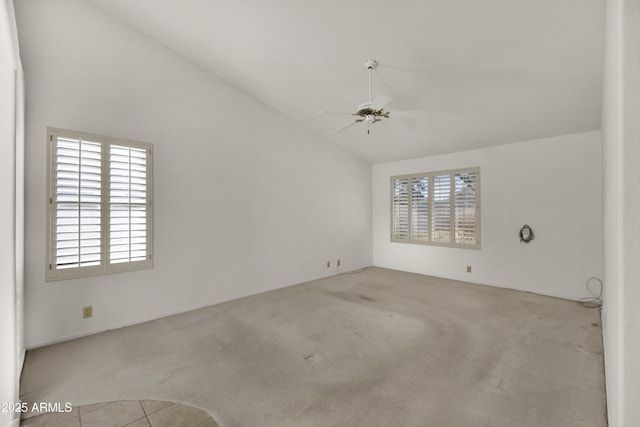 carpeted empty room with ceiling fan and lofted ceiling