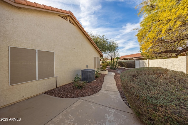 view of side of property with cooling unit and a patio