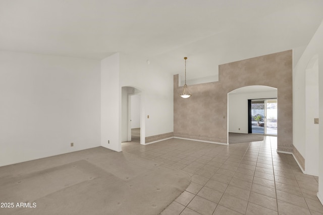 tiled spare room with a towering ceiling