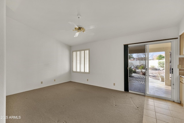 empty room featuring light carpet, vaulted ceiling, and ceiling fan