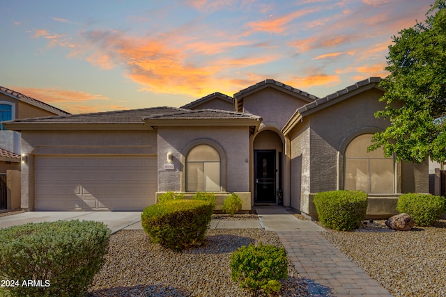 view of front of house with concrete driveway, an attached garage, and stucco siding