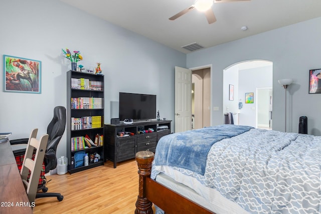 bedroom featuring visible vents, arched walkways, ceiling fan, and wood finished floors