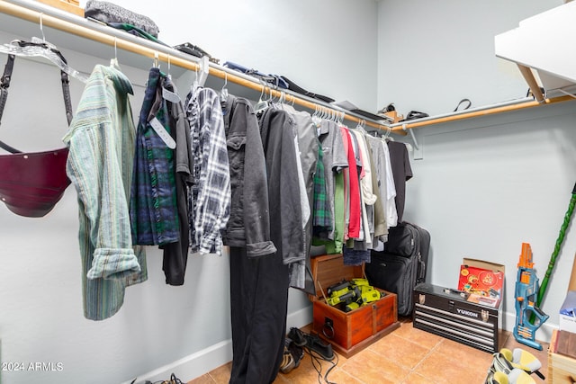 walk in closet with light tile patterned floors