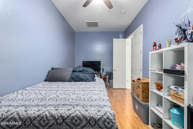 bedroom featuring ceiling fan, wood finished floors, and visible vents