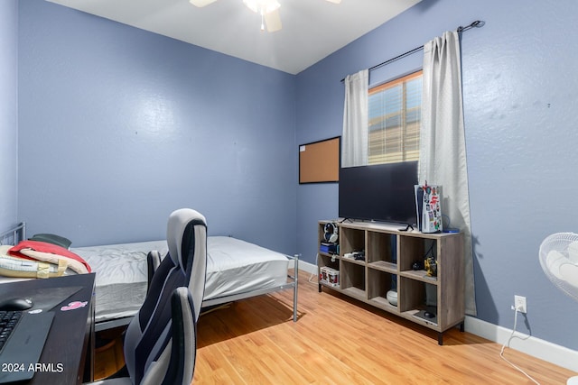 bedroom with ceiling fan, baseboards, and wood finished floors