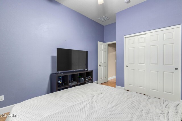 bedroom with ceiling fan, vaulted ceiling, light hardwood / wood-style flooring, and a closet