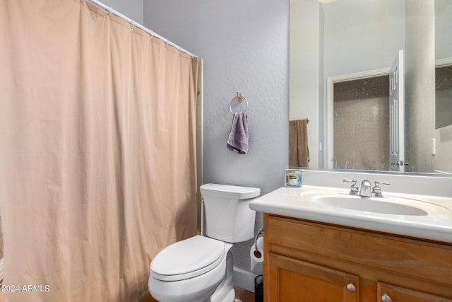 bathroom featuring a textured wall, vanity, toilet, and a shower with curtain