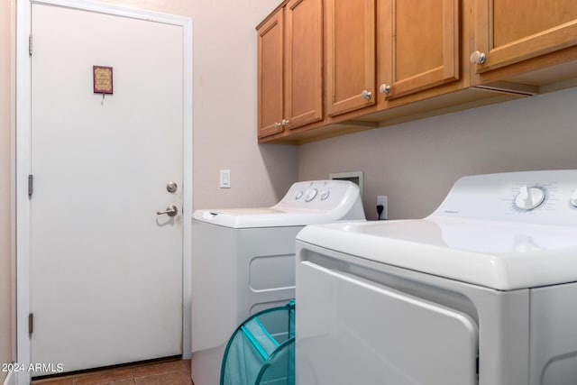 laundry room with cabinet space, washer and dryer, and tile patterned floors