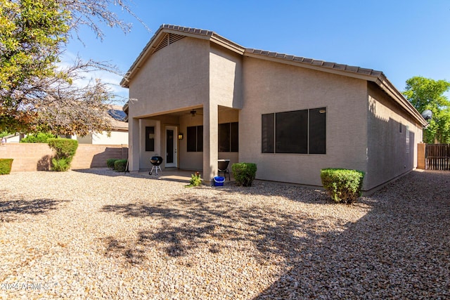 back of house with a patio area, ceiling fan, fence, and stucco siding