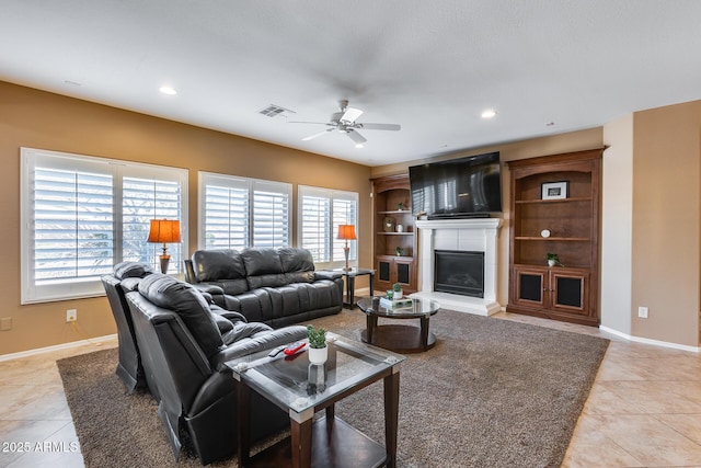 9952 W Jessie Ln, Peoria, AZ 85383 - living room with ceiling fan, light tile patterned floors, a glass covered fireplace, baseboards, and recessed lighting