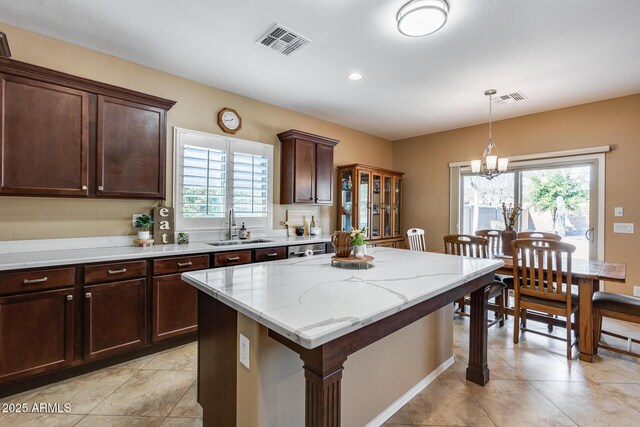 9952 W Jessie Ln, Peoria, AZ 85383 - kitchen with a sink, a chandelier, dark brown cabinetry, pendant lighting, and a kitchen island