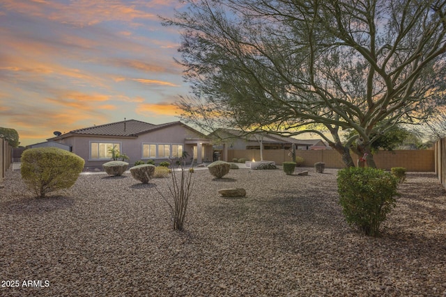 9952 W Jessie Ln, Peoria, AZ 85383 - back of property at dusk with a fenced backyard, stucco siding, and a tiled roof