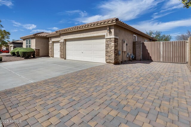 9952 W Jessie Ln, Peoria, AZ 85383 - view of property exterior with stucco siding, driveway, an attached garage, and stone siding