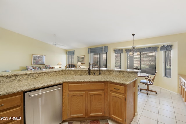 kitchen featuring sink, decorative light fixtures, vaulted ceiling, light tile patterned floors, and stainless steel dishwasher