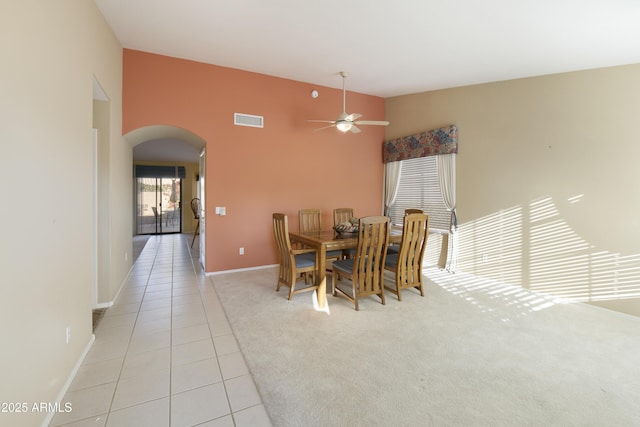 tiled dining area with ceiling fan and lofted ceiling