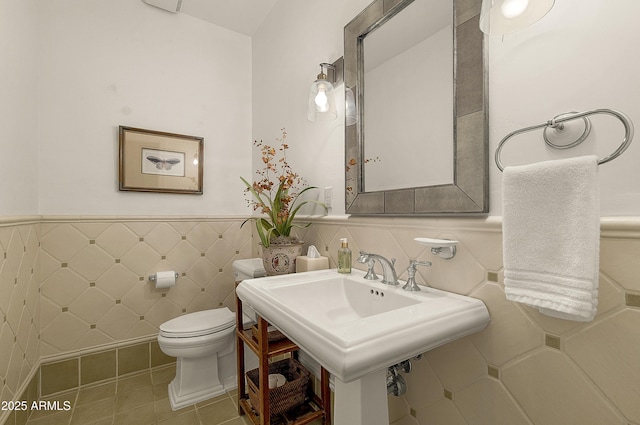 2036 Bessie Kidd Best, Flagstaff, AZ 86005 - half bathroom with toilet, wainscoting, tile walls, tile patterned floors, and a sink