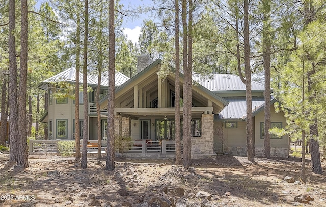 2036 Bessie Kidd Best, Flagstaff, AZ 86005 - back of house with metal roof, covered porch, a chimney, and stone siding