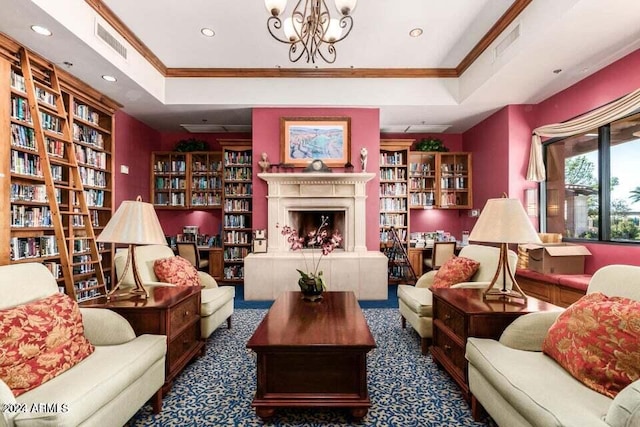 living area with carpet, ornamental molding, an inviting chandelier, a raised ceiling, and a tile fireplace